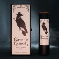 Raven's Remedy ritual candle displayed with its illustrated packaging