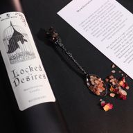 Close-up of the Locked Desires candle label with a bat inside a cage